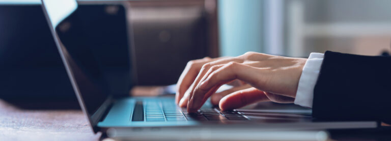 Close up of business woman hands typing on laptop computer and searching web, browsing in the workplace at office. proportion of the banner for advertisement